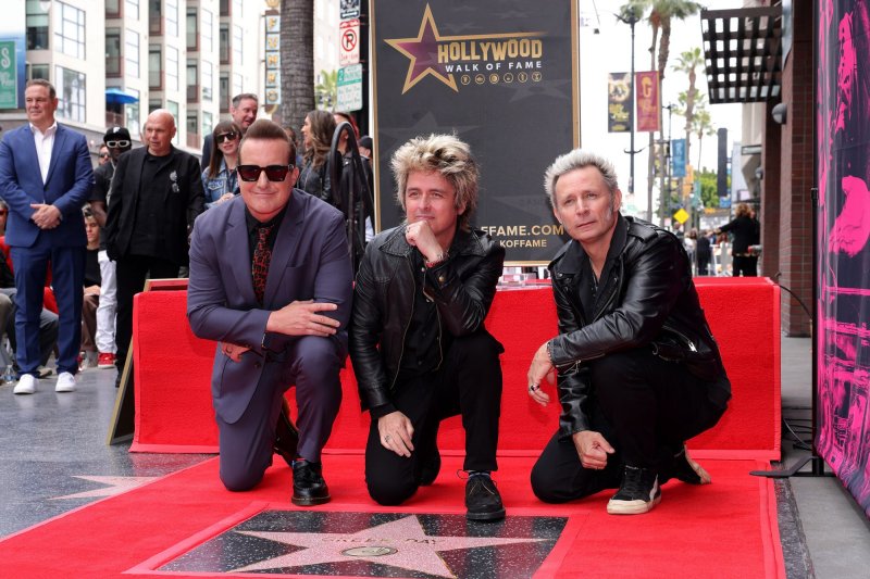 Tré Cool, Billie Joe Armstrong and Mike Dirnt, from left to right, of Green Day pose with their star during an unveiling ceremony honoring them with the 2,810th star on the Hollywood Walk of Fame on Thursday. Photo by Greg Grudt/UPI