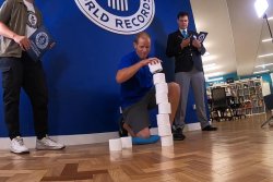 Man stacks toilet paper rolls with one hand to break world record